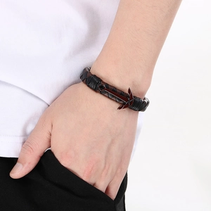 Detail showing the anchor clasp and woven leather texture on a men's bracelet