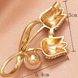 Goldene Tulpenperle Brosche für Anzüge mit Maßen 5,4cm x 3cm auf rosa Stoff
