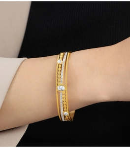 Detailed close-up of layered vintage gold-plated cuff featuring marble beads and crystals