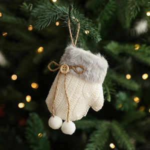 Plush sleigh Christmas ornament with wood button on tree branch, cozy festive atmosphere