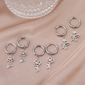 Polished stainless steel hoop earrings featuring hollow floral patterns on satin background
