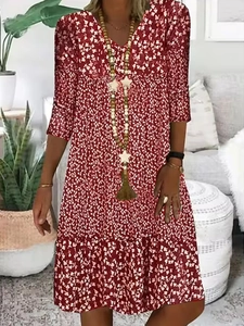 Detail of V-neckline and floral print on a burgundy midi dress with mid-length sleeves