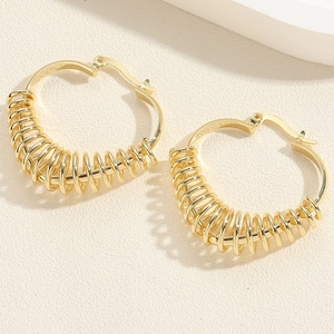 Detail of gold spiral coiled hoop earrings with fine metallic wire wrap texture
