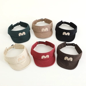 Detailed flat lay of kids sun visor hats in six colors with embroidered letter M