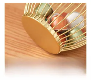 Close-up of golden coffee pod holder with a flat base on a warm wooden tabletop