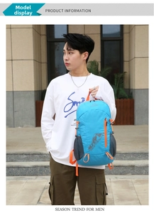 Blue foldable backpack with orange zippers and side mesh pocket shown in outdoor use