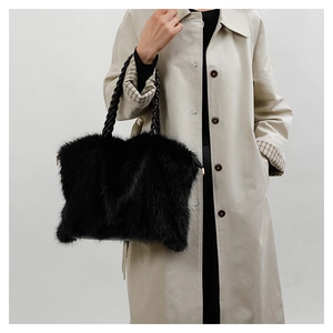 Detail of black faux fur tote bag showing the plush texture and woven cord handles