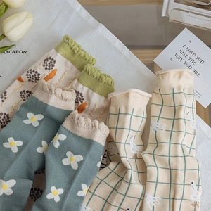 Vintage cotton floral and plaid socks with ruffle edges on white textured background