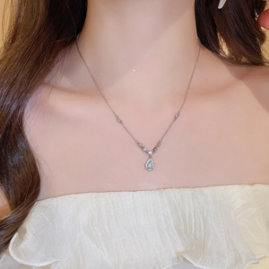 Detailed view of water drop pendant necklace with tiny crystals on a woman's neck