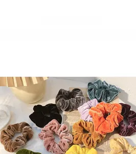Detail of assorted velvet scrunchies in retro colors shown on a decorative tray