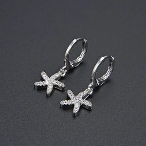 Detailed view of silver starfish drop earrings with white cubic zirconia and secure clasp