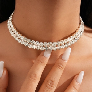 Close-up of elegant double-layered gold choker necklace with sparkling white rhinestones