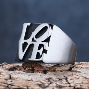Industrial style silver stainless steel LOVE ring displayed on natural wood bark