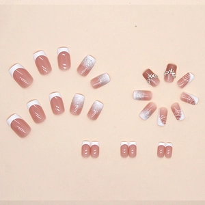 French style press-on nails with nude pink gradient, white tips and glitter accents
