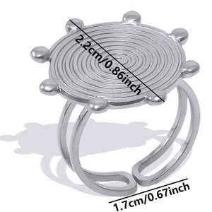 Macro detail of adjustable steel ring with engraved swirl texture and beaded circle