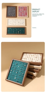 Detailed view of stackable wooden ring display trays with multi-color velvet inserts