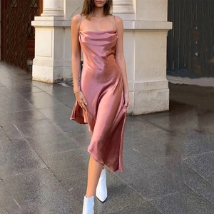 Détail d'une élégante robe en satin rose avec col bénitier et ourlet asymétrique