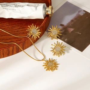 Dettaglio macro del set di gioielli a girasole con cristalli lucidi placcati oro