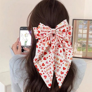 White bow hair clip with red hearts and LOVE print shown from a back-view perspective