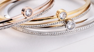 Macro detail of luxury bangles in gold and silver with large central stones and crystals