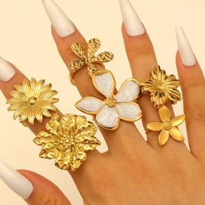 Close-up of a gold floral ring set featuring daisy and rose designs on a model hand