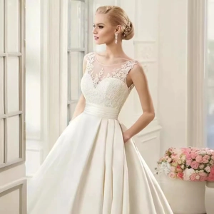 Elegant A-line ivory lace wedding dress with sleeveless sheer neckline and satin skirt