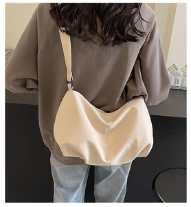 Rear view of off-white large capacity crescent tote bag with wide adjustable shoulder strap