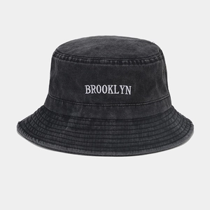 Détail de la broderie Brooklyn blanche sur bob en jean délavé gris foncé
