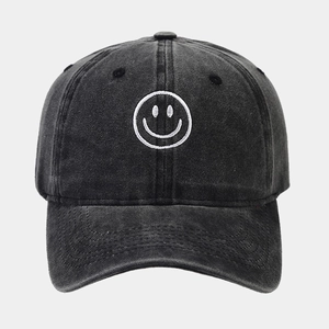 Washed black denim baseball cap with white embroidered smiley face and curved brim