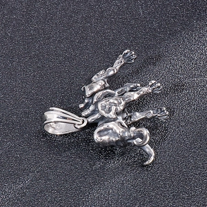 Macro shot of a vintage silver dragon pendant with detailed metallic texture on black surface
