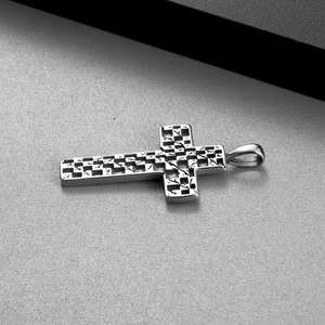 Detail shot showing the polished silver stainless steel cross pendant with checkered texture