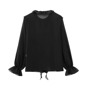 Detail der schwarzen Chiffonbluse mit Rüschenkragen, Lagenmanschetten und Bindesaum