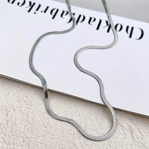 Macro shot of silver titanium steel flat snake bone chain with a smooth metallic texture