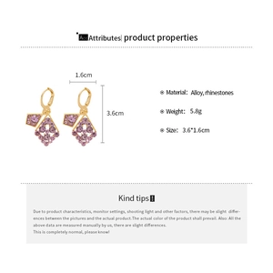 Macro detail of geometric rhombus earrings with purple rhinestones and 3.6x1.6cm dimensions