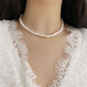 Elegant natural freshwater pearl necklace on a model wearing a white lace dress