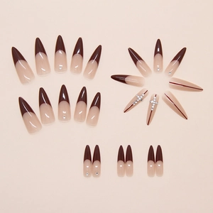 Detail of dark red French tip press-on nails with sparkling rhinestones and cross motifs