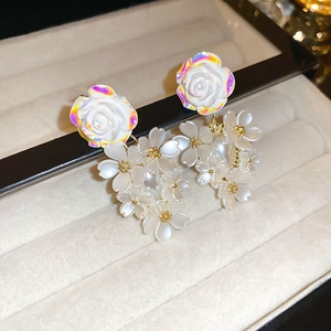 Detailed macro view of white floral stud earrings with pearl luster in a jewelry box