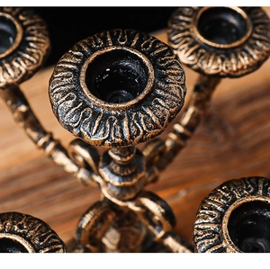 Close-up of vintage bronze candelabra detailing with classical embossed carvings