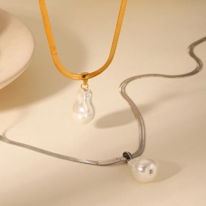 Gros plan de chaînes serpent dorées et argentées avec pendentifs perles baroques