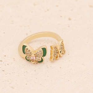 Adjustable gold butterfly ring featuring green enamel wings and pink marquise gemstone