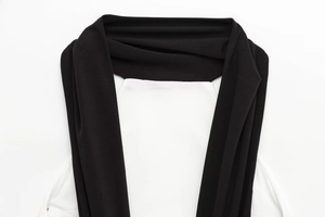 Close-up of contrast black and white halter neckline detail on a knit mini dress