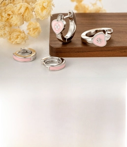 Detail of silver heart earrings with pink enamel and cross pattern for women