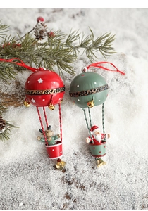 Detail of red reindeer and green Santa hot air balloon metal ornaments with gold bells