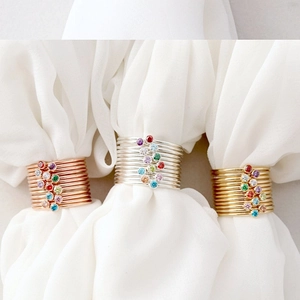 Close-up of thin minimalist rings in gold, silver, and rose gold finishes with colorful gems