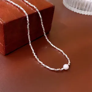 Collier minimaliste en perles d'argent avec perle d'eau douce sur boîte en cuir