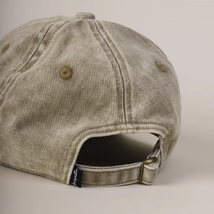 Macro detail of washed cotton baseball cap with adjustable metal strap and vintage texture