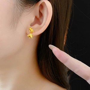 Détail du clou d'oreille carpe koi plaqué or porté, montrant les textures des écailles