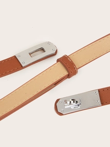 Macro shot of brown Saffiano leather belt featuring a silver Kelly-style twist lock closure