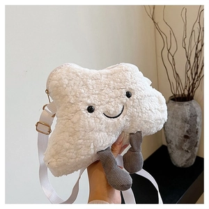 Detail of white fluffy cloud bag with smiling face embroidery and grey corduroy legs