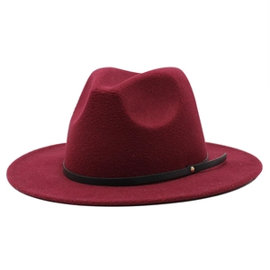 Detail of burgundy wool fedora hat featuring black leather band and golden metal rivet